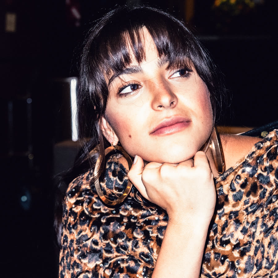 Model in leopard print leaning into a direct-flash portrait