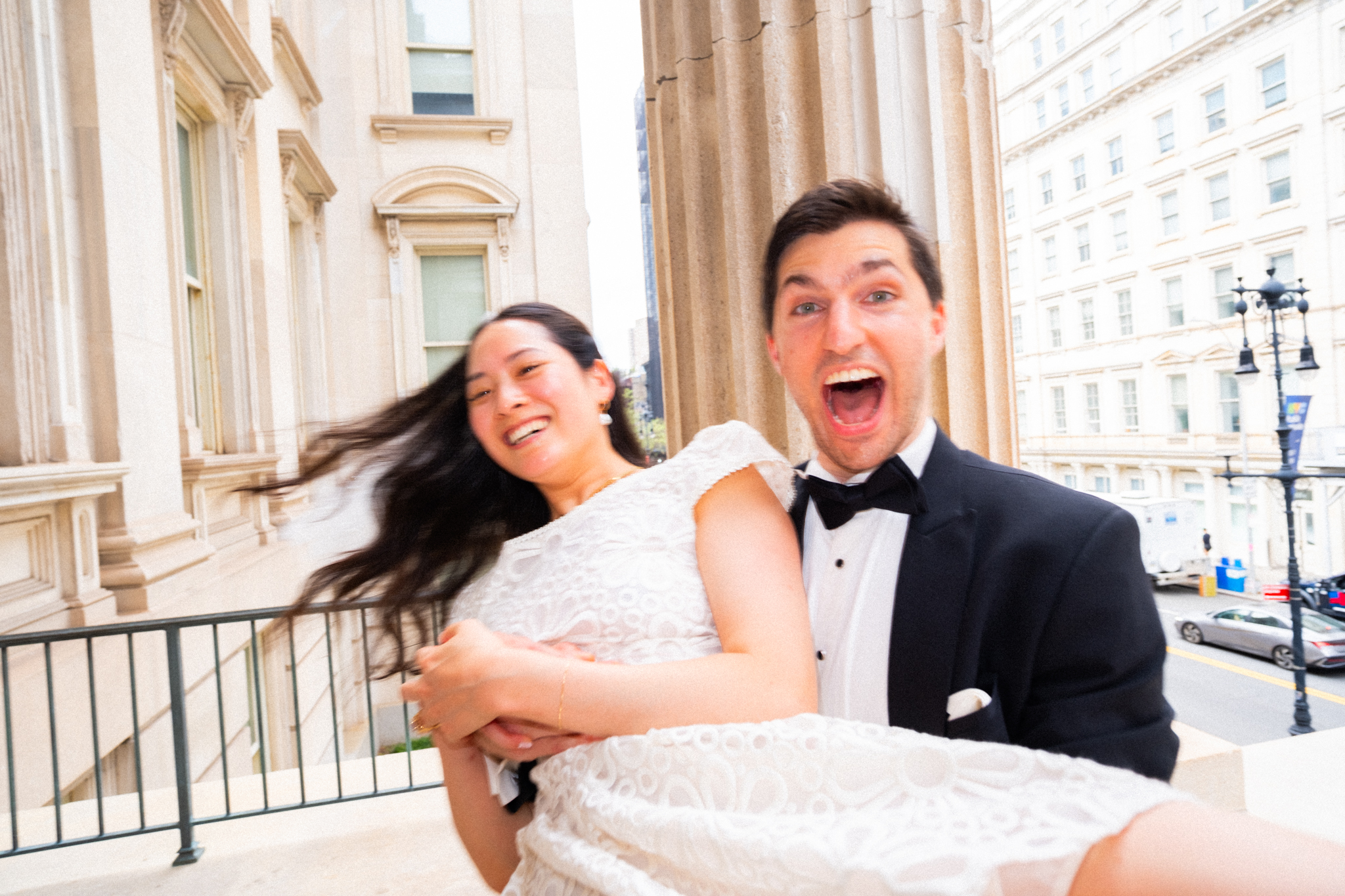 Alex carrying Joyce along the courthouse balcony as they laugh
