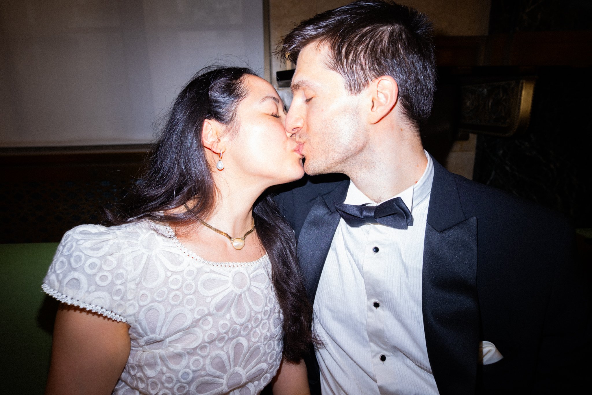 Joyce and Alex kissing in a close direct-flash portrait